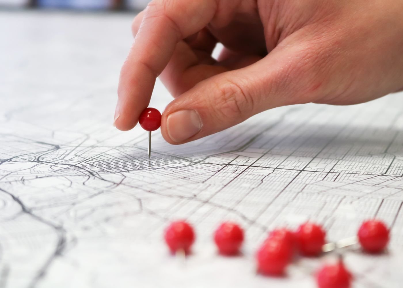 Hand placing a pin on a map representing local search visibility