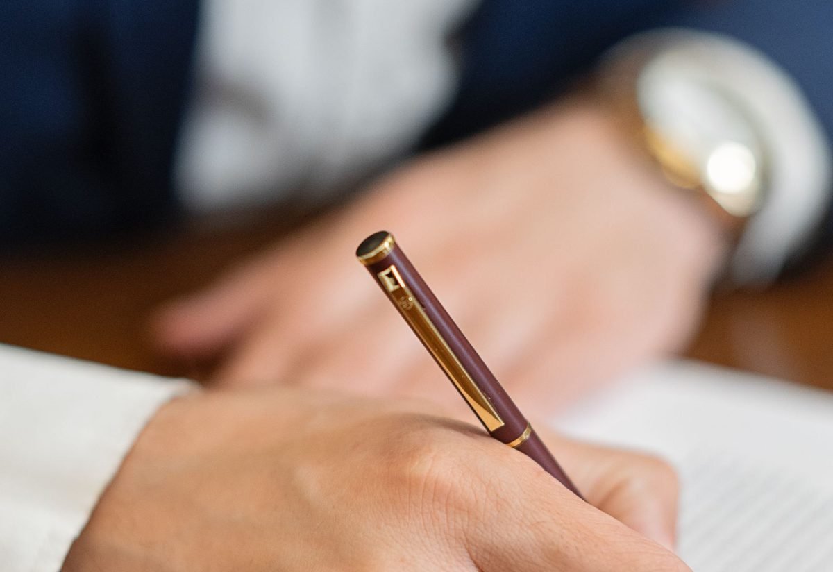 Hand signing a legal document with a pen