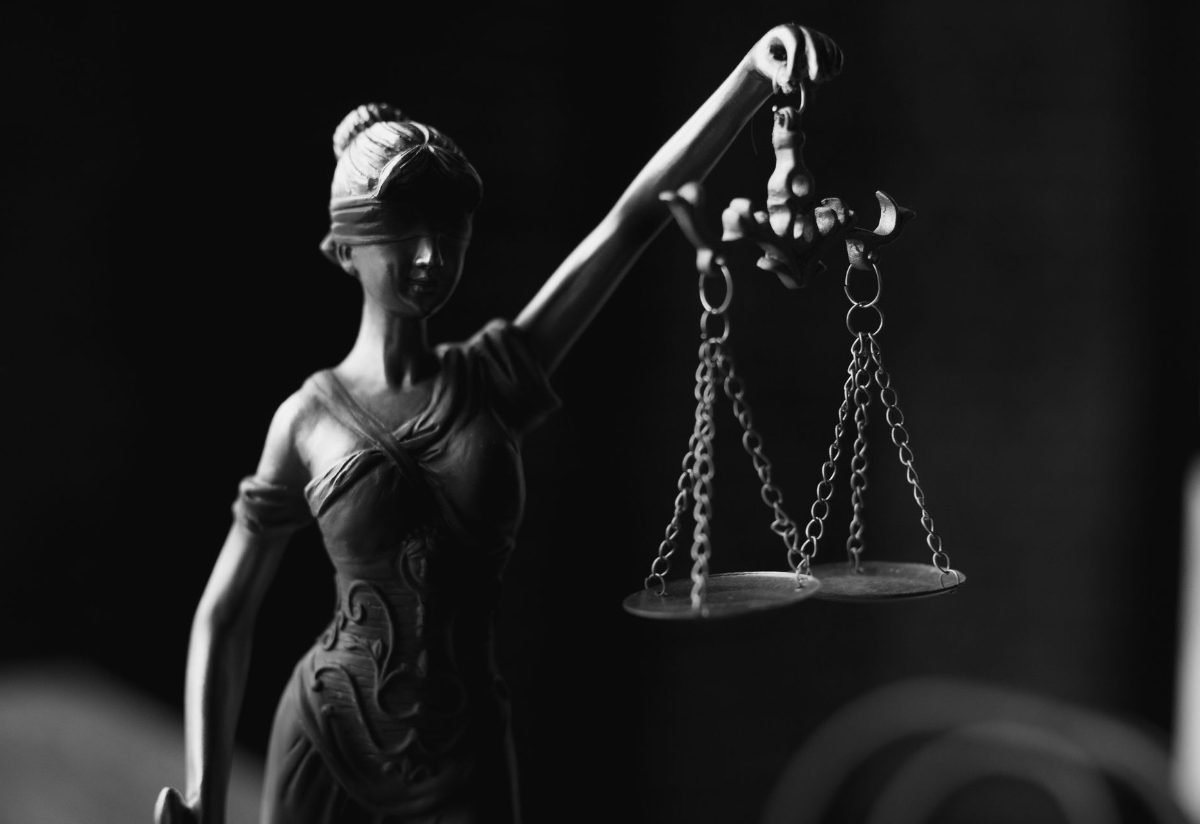 Lady Justice statue holding scales in dramatic light